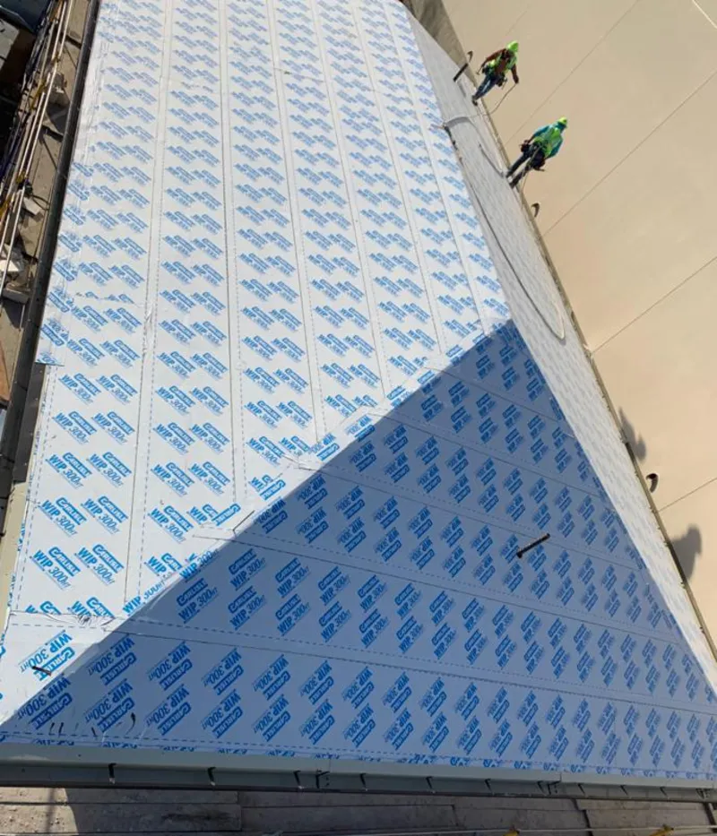 Professional roofers installing underlayment on a metal roof in Valley Center